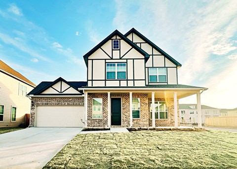 a house with a green lawn and a blue sky in the background